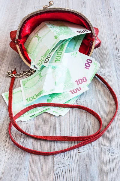 100 billets en euros tombent du sac à main rouge — Photo