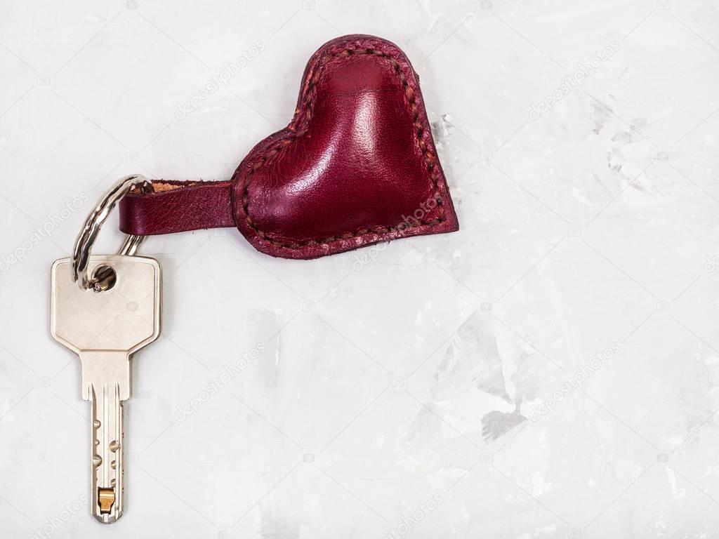 door key with heart shape keychain on concrete