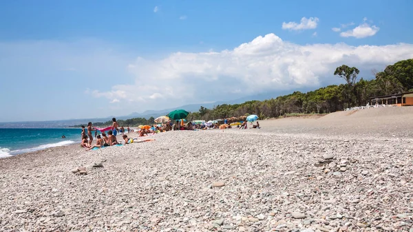 Turister på pebble beach San Marco på Joniska havet — Stockfoto