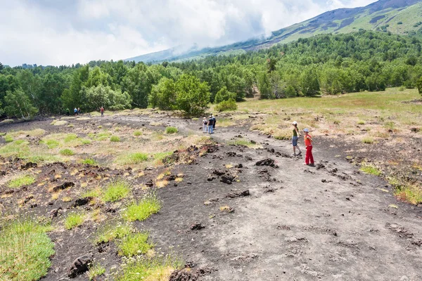 Turister vandrar på väg på sluttningen av mount Etna — Stockfoto