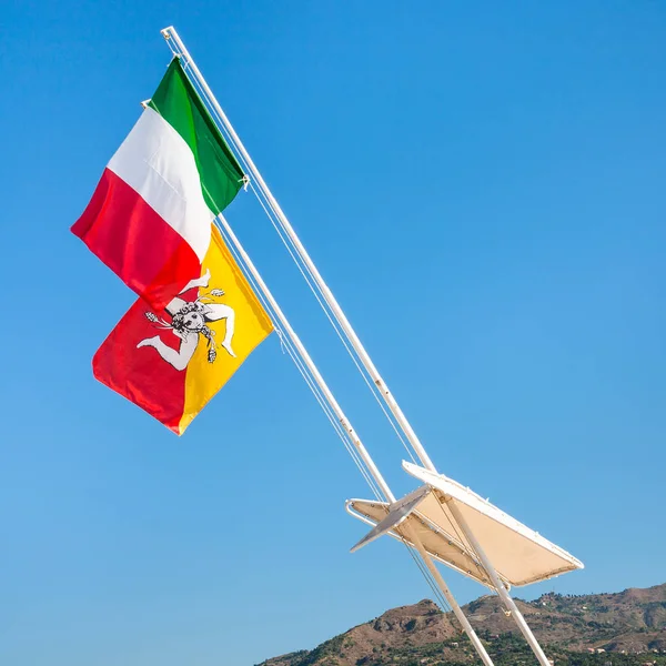 Italian and Sicilian flags and blue sky