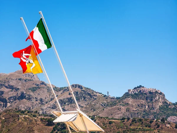 Italian and Sicilian flags flutter by wind