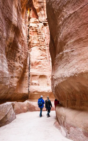 Turistas caminan en estrecho pasaje Siq a la ciudad de Petra — Foto de Stock