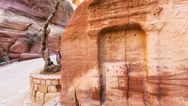 Turistas cerca del relieve de piedra en Al Siq pasar a Petra — Foto de Stock