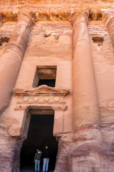 Turistas na porta do túmulo de urna real na cidade de Petra — Fotografia de Stock