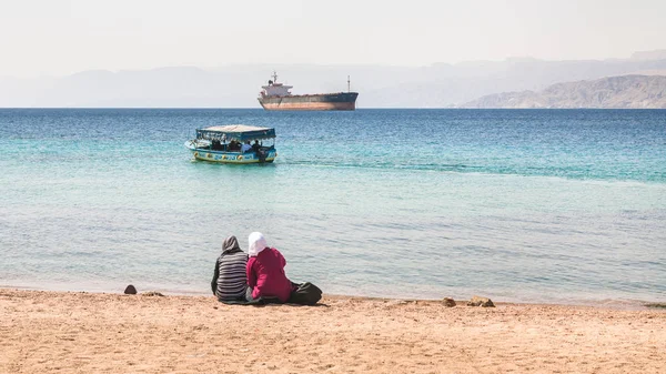 Donne musulmane sulla spiaggia urbana nella soleggiata giornata invernale — Foto Stock