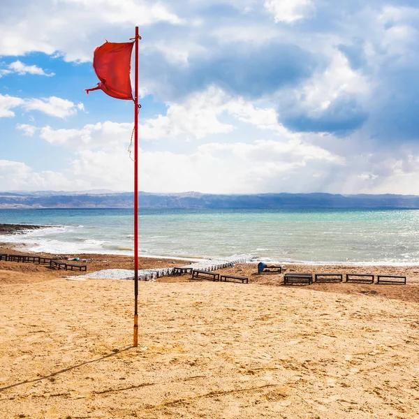 Red flag on beach on Dead Sea in winter season — Stock Photo, Image