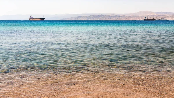 Helder water in de buurt van stedelijke strand van Aqaba stad — Stockfoto