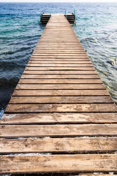 Houten pier op koraal beach van rode zee in Aqaba — Stockfoto