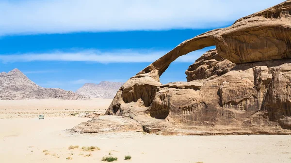 Машина рядом со скалой из песчаника в пустыне Вади Рам — стоковое фото