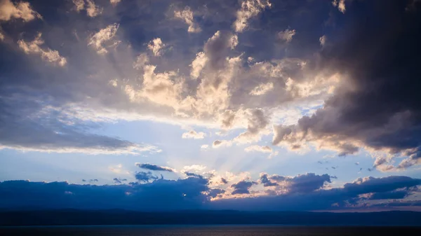 Blauwe zonsondergang wolken boven de dode zee in winteravond — Stockfoto