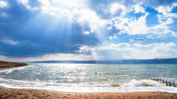 Ölü Deniz üzerinde mavi bulutlar güneş ışınları geçer — Stok fotoğraf