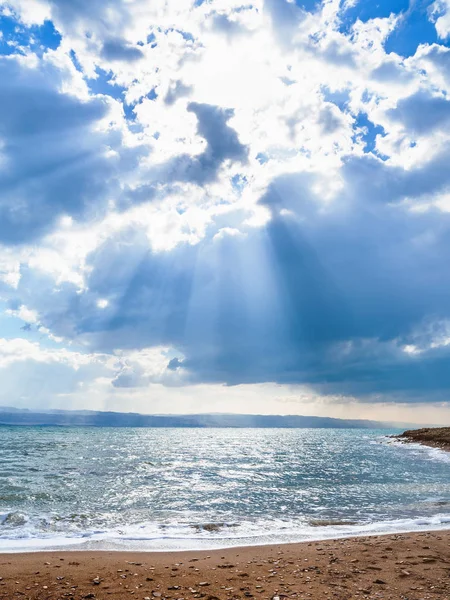 Luz solar passa através de nuvens azuis sobre o Mar Morto — Fotografia de Stock