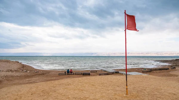 Rode vlag op het strand van de dode zee in de winter — Stockfoto