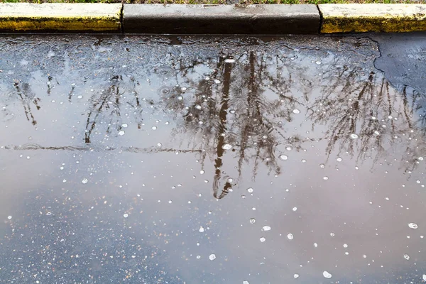 Калюжа на міській вулиці в дощовий день — стокове фото