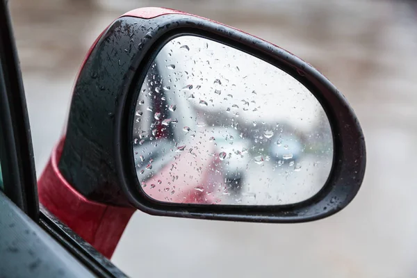 Gotas de lluvia en el espejo retrovisor lateral en días lluviosos — Foto de Stock