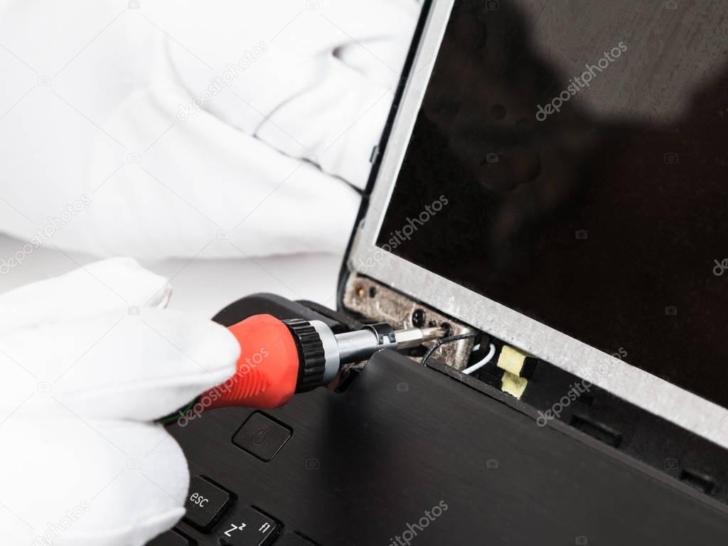 serviceman in white gloves fixes LCD screen