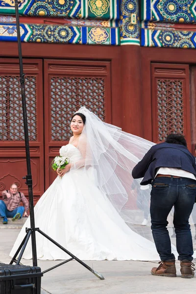 Фотограф и невеста на дворе храма — стоковое фото