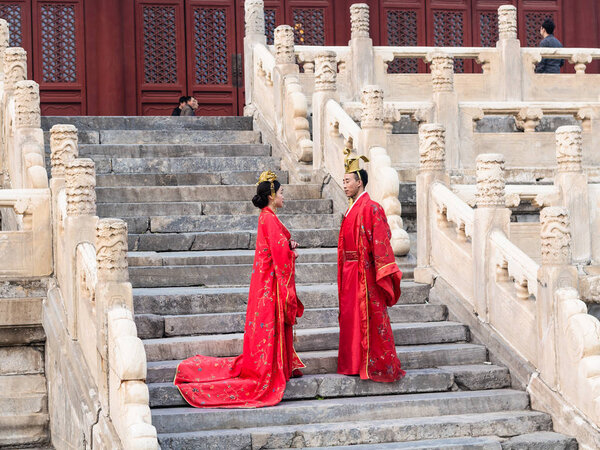 пара в традиционных костюмах на ступенях Храма
