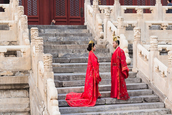 пара в китайских платьях на ступенях Храма
