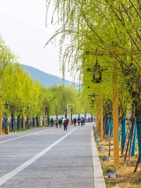 Tourists on waterfront walk to Longmen Grottoes — Stock Photo, Image