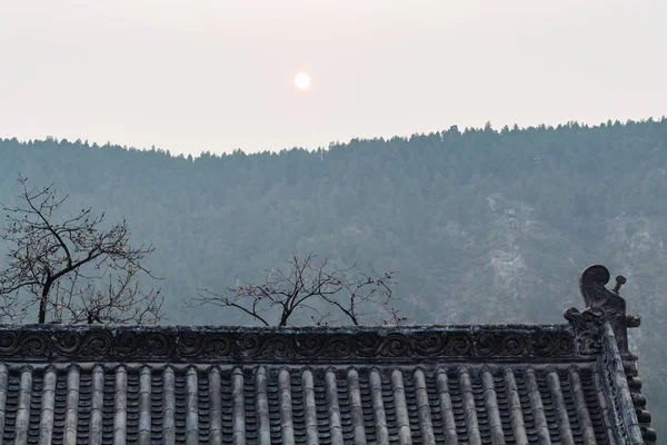 龍門の東の丘の上の寺院の屋根の上の太陽 — ストック写真