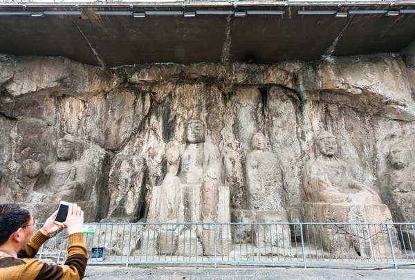 Tourist take photo of carved Buddha figure — Stock Photo, Image