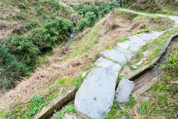 Natte traject en irrigatie sloot op de helling van de heuvel — Stockfoto