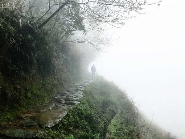 Homme au sentier humide sur la pente de la colline sous la pluie — Photo