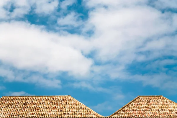 Nubes blancas en el cielo azul sobre techos de azulejos anaranjados —  Fotos de Stock