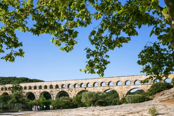 Touristen besuchen das antike römische Aquädukt pont du gard — Stockfoto