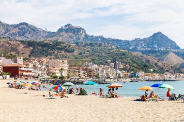 Giardini Naxos şehirdeki kum plajı üzerinde kişi