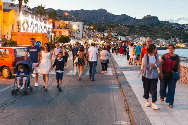 Les gens marchent à Giardini Naxos dans la soirée — Photo