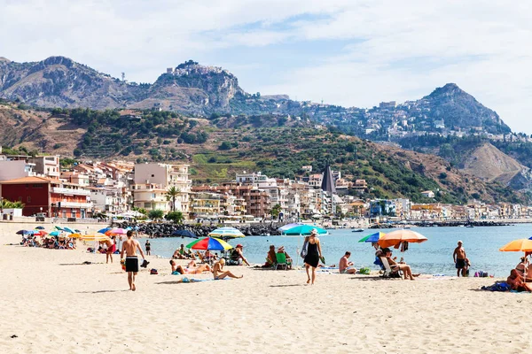 Vakantiegangers op zand strand in Giardini Naxos stad — Stockfoto