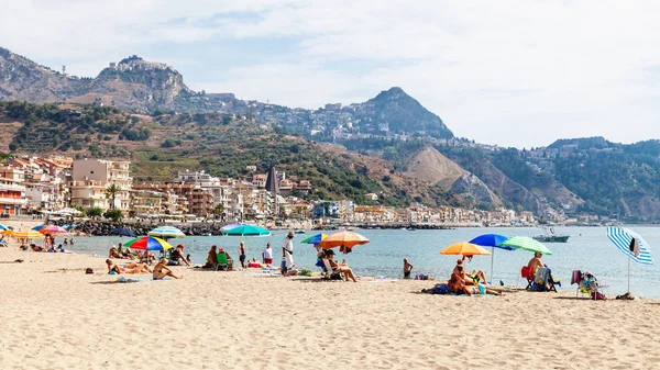 Toeristen op zand strand in Giardini Naxos stad — Stockfoto