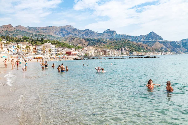 Personnes en mer près du front de mer de Giardini Naxos — Photo