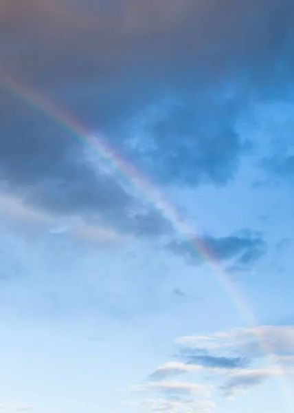 Arcobaleno tra nuvole scure nel cielo blu della sera — Foto Stock