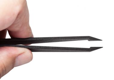 fingers hold plastic tweezers with sharp tips clipart