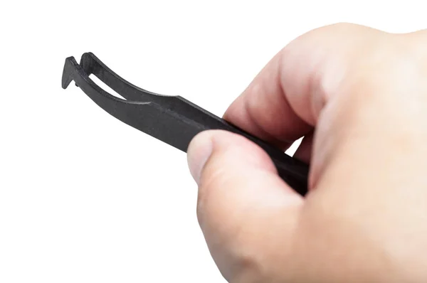 Male hand with black plastic anti-static tweezers — Stock Photo, Image