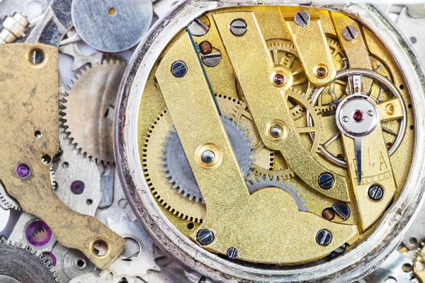 Brass mechanical watch on pile of spare parts — Stock Photo, Image