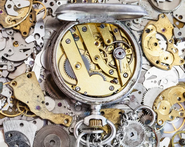 Open used pocket watch on pile of spare parts — Stock Photo, Image