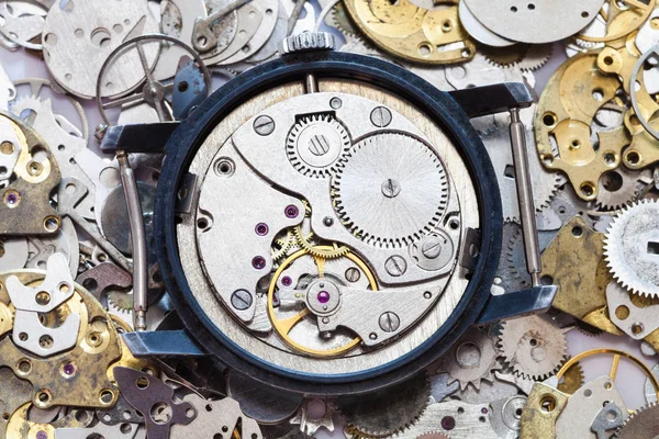 Used mechanical wristwatch on heap of spare parts — Stock Photo, Image