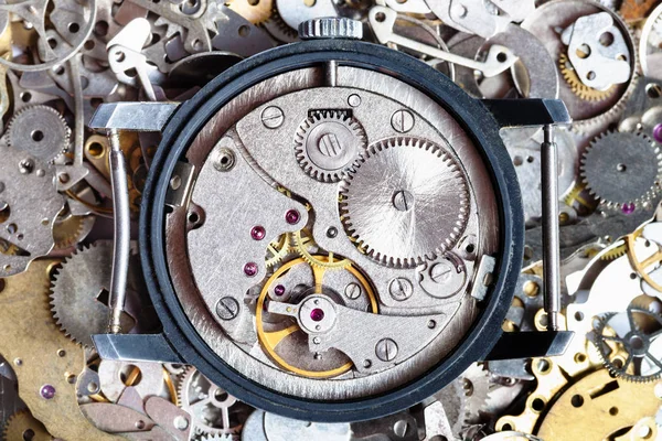 Open vintage watch on heap of clock spare parts — Stock Photo, Image