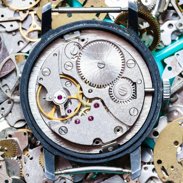 Clockwork on heap of clock spare parts — Stock Photo, Image