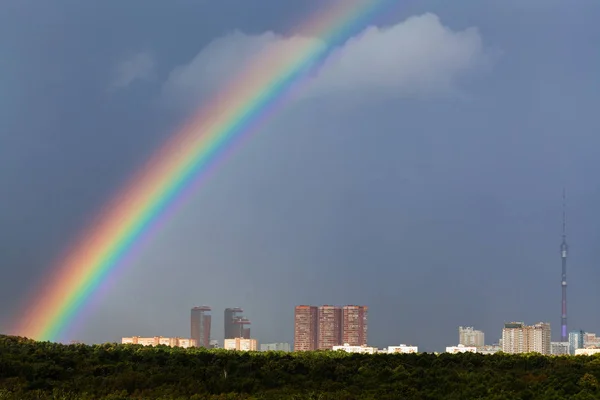 Regenboog in grijze lucht over stad met Tv-toren — Stockfoto