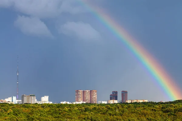 Arc-en-ciel dans le ciel pluvieux sur la ville avec tour de télévision — Photo