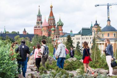 tourists on hill in Zaryadye park and Kremlin clipart