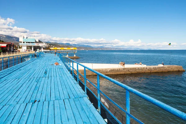 People sunbathe on wood solarium in Alushta — Stock Photo, Image