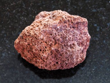 koyu arka plan üzerinde kırmızı ponza taşı, çakıl taşı