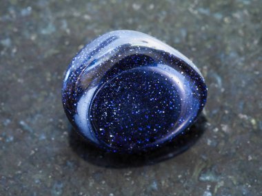 polished blue goldstone gemstone on dark clipart